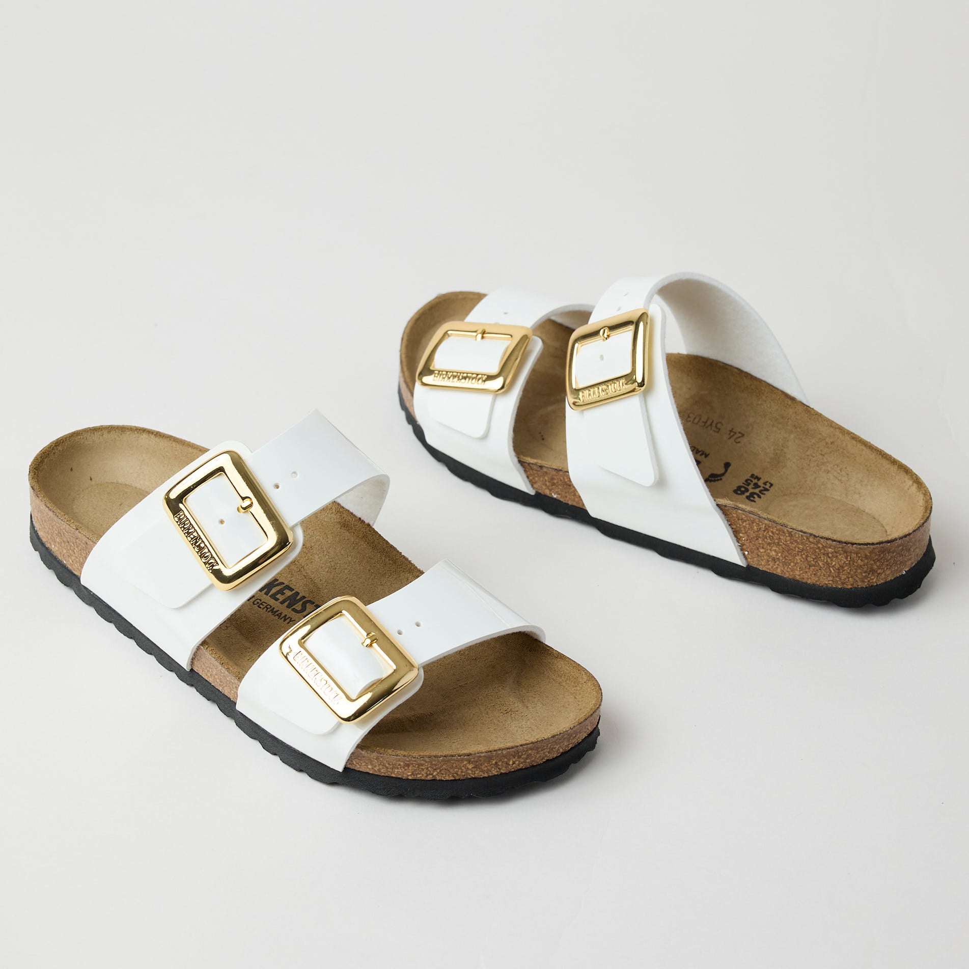white birkenstocks with gold buckles